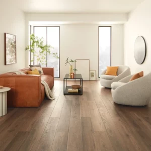 COREtec Luxury Vinyl in a dark brown wood tone in a bright living room | Broadway Carpet & Flooring