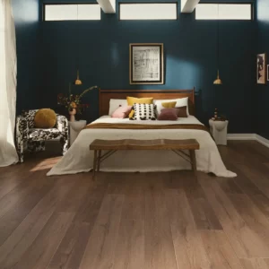 COREtec Luxury Vinyl in a medium brown wood tone in a bedroom | Broadway Carpet & Flooring